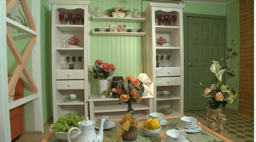 Характерная отделка помещения: окрашенная в пастельные тона доска, и белые открытые шкафчики для посуды 