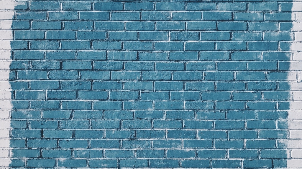 Фото: нанесение голубой краски на обработанную кирпичную стену